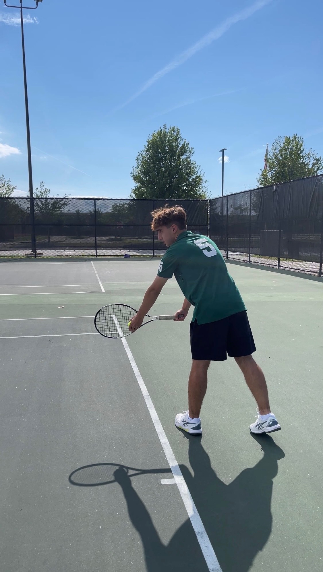 Daniel preparing to serve on the tennis court